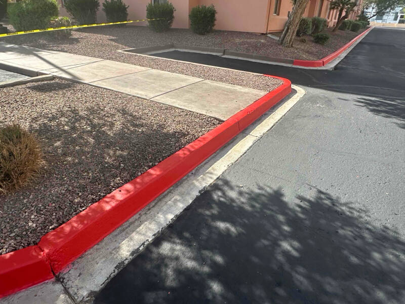 Red fire lane curb painting and no parking zone markings at a Baton Rouge commercial property