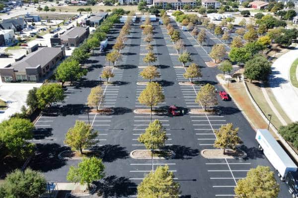 Wide view of a freshly striped commercial parking lot with clear yellow lines and directional arrows in Baton Rouge